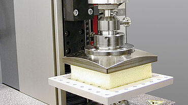 Твердость при осадке по ASTM D3574 Test C, детальный снимок испытательного приспособления с нормативным образцом из пенного материала